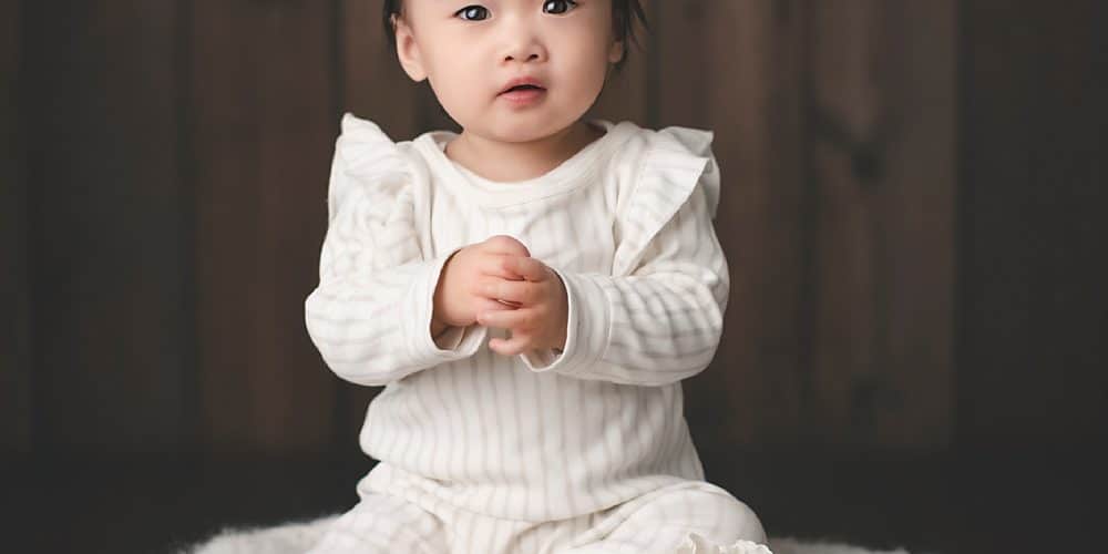 Photo of One Year Old girl sitting on a box in a photography studio in Northern Virginia